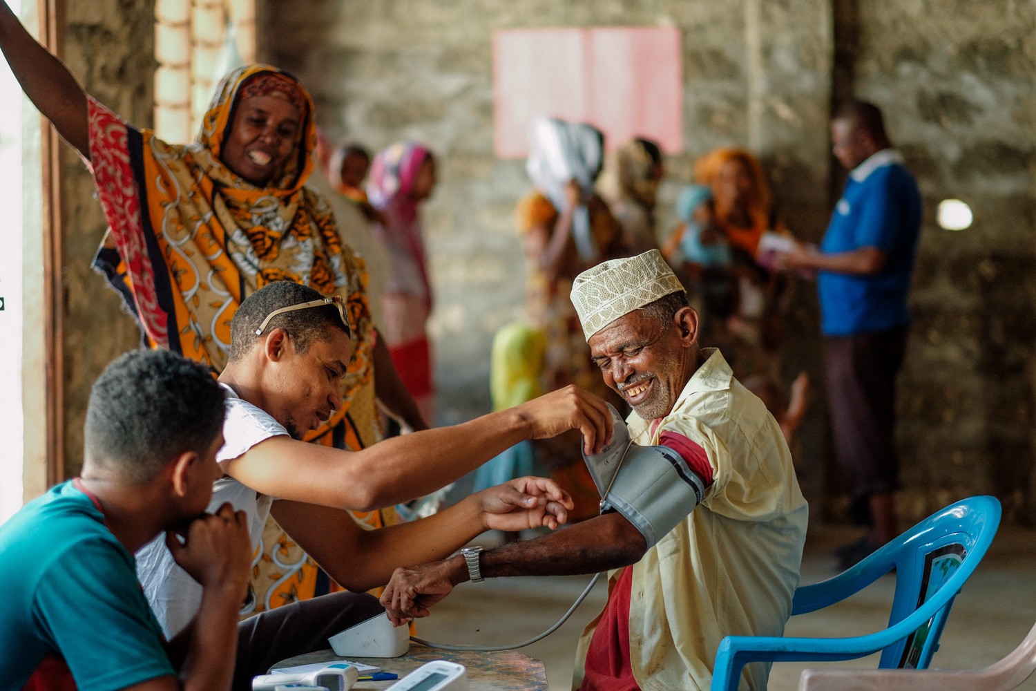 A health worker checks an elderly patient's blood pressure